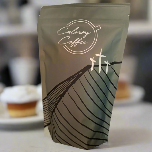 Calvary Coffee bag on a counter with sweets.